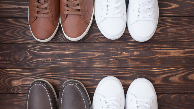 Various pairs of colorful sneakers laid on the wooden floor background