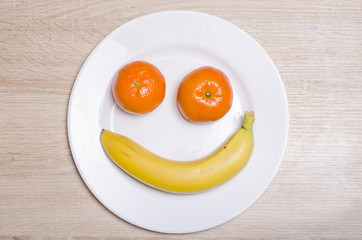 Fresh fruit on wooden table with white plate. 
