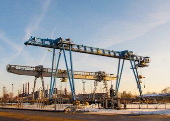 Fototapeta na wymiar Two bridge crane against a blue sky