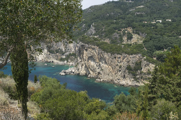 Sea rocks along Ionian sea coast in Paleokastritsa resort in June. Corfu Island, Greece