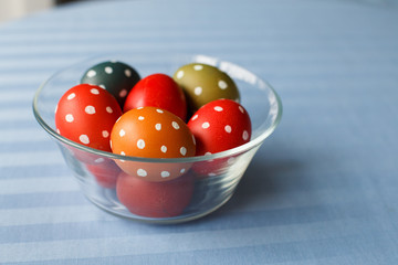 Easter eggs painted in bright colors on a blue textil background