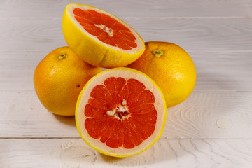 Ripe fresh grapefruits on white wooden table
