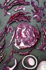 Obraz premium Arrangement of colorful red cabbage and red onion on slate table