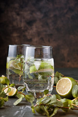 Glasses of Mojito with lime and mint. Summer refreshing cocktail on a grey metal background