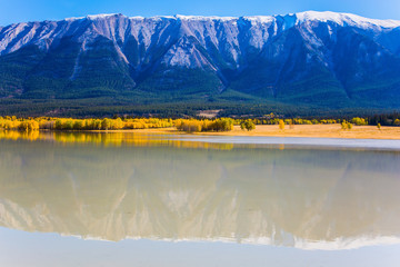 Rocky Mountains are reflected in the smooth water