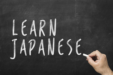 Obraz premium Human hand writing text on blackboard: Learn japanese