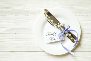 Easter laying table appointments, table setting options. Silverware, tableware items with festive decoration. Fork, knife and flowers. Happy easter holiday.