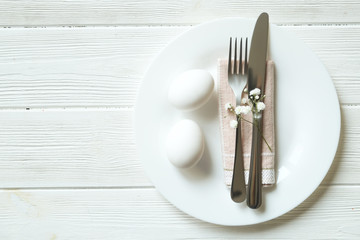 Easter laying table appointments, table setting options. Silverware, tableware items with festive decoration. Fork, knife and flowers. Happy easter holiday.