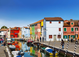 Obraz premium Urban landscape on the island of Burano with colorful buildings and tourists on the streets, Venice, Italy