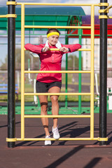 Fitness and Healthy Lifestyle Concepts. Smiling Caucasian Female Athlete in Professional Outfit Posing With White Towel Near the Trainer Outdoors.