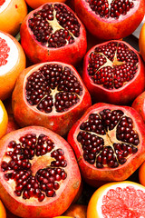 Ripe red garnet with cut up top, pomegranate seeds close-up