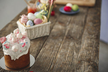 Close up of sweet bread and box with colored eggs on the timbered desk. Focus on bakery. Copy space in right side