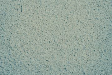 Rough plastered wall of light green color - background, texture