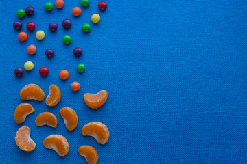 kids menu written by candies and mandarins on blue background 