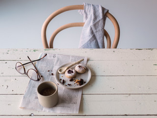 Frükstücksszene mit Kaffee, Gebäck und Zeitung