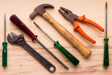 Screwdrivers, hammer, pliers and tools on a wooden table