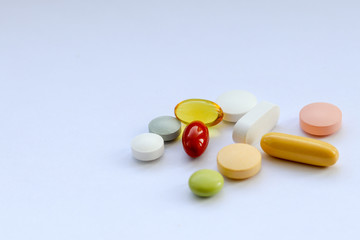 Different pills, tablets and vitamins on white background, close-up