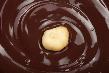 Melted chocolate swirl with hazelnut as a background closeup
