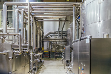Modern brewery interior. Filtration vats, pipeline, valves and other equipment of beer production line