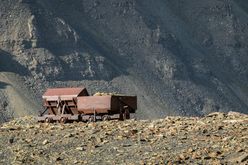 Naklejka premium Old abandoned coal wagons, used for the coal mining industry, mountain background Longyear valley, Svalbard Norway. Arctic landscape.
