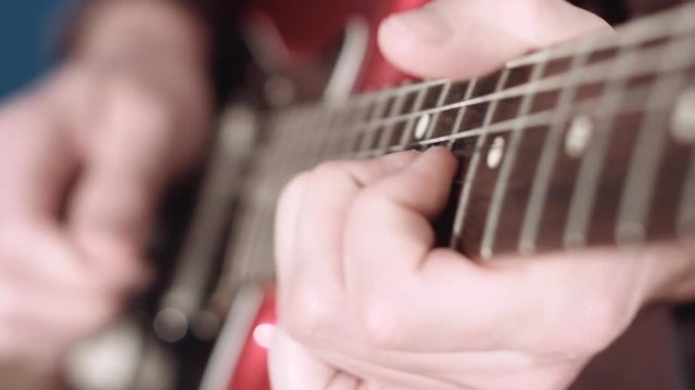 Detail of guitarist performing a solo on electrig guitar, selective focus
