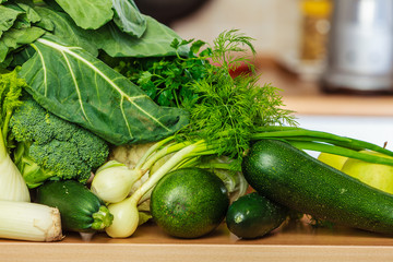 Many green vegetables on kitchen table