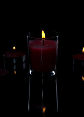 candle light with back light on a black background with reflection