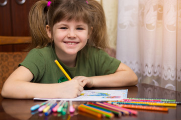 Cute portrait of little kid girl drawing by multi-colored pencils. concept of kids hobby or childhood, happy lifestyle