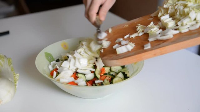 the chef prepares the salad and mixes the ingredients