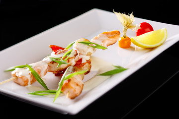 Restaurant dishes with seafood skewers with salmon and shrimp