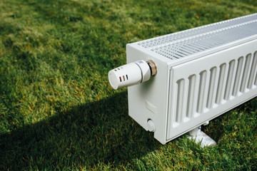radiator on green lawn, ecological heating concept