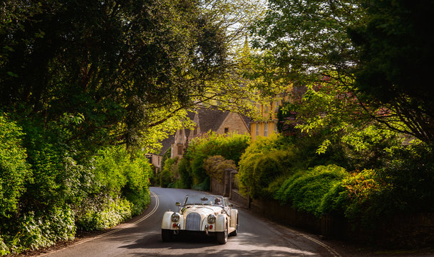 Retro vintage antique classic sport car, automobile, auto on the old english street in United Kingdom Great Britain. Motor transport for drive, travel, transportation. Vintage effect style picture.