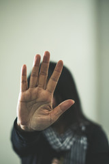 Girl being struck. Portrait of young girl with bruises on her face showing stop sign, palm in focus