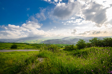 Fototapeta na wymiar Majestic landscape of mountains and Meadow. Cycling mountain road. Misty mountain road in high mountains.. Cloudy sky with mountain road.