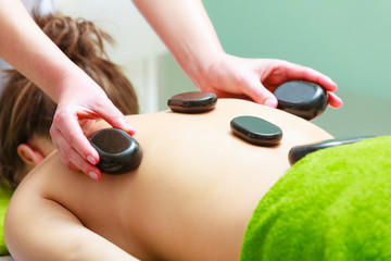 Massage with hot rocks stones in beautician