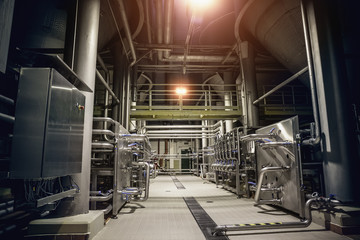 Modern brewery factory interior.Steel tanks or vats for filtration beer, pipe lines and other...