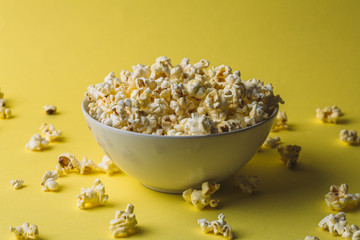 Popcorn in bowl on yellow background