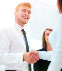 funny smiling businessman shaking hands with his partner.