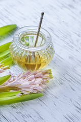 Honey vintage jar on white wooden background with pink hyacinth