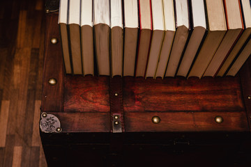 A bunch of old, dirty books on a wooden chest