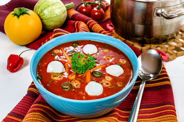 Spicy chili hot tomato soup with sour cream ball in a bowl.
