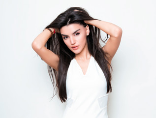 Fototapeta premium beautiful young woman with long black hair posing in white dress