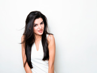 Fototapeta premium beautiful young woman with long black hair posing in white dress