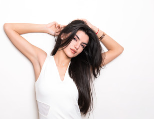 Naklejka premium beautiful young woman with long black hair posing in white dress