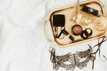 Top view fashion gold and black  accessories. Mask, coffee, lipstick and lace lingerie. Set of woman essential accessory and underwear on flat lay.