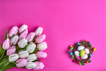 Easter background. Decorative Easter eggs and pink tulips. Holiday card. Copy space, top view.