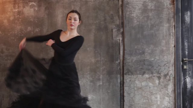 the elegant lady in a black ballet swimsuit is danced in dance, the woman uses the skirt of a transparent skirt to create an art performance