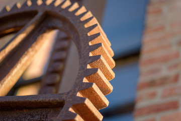 macro closeup of large rusty industrial gear outside factory
