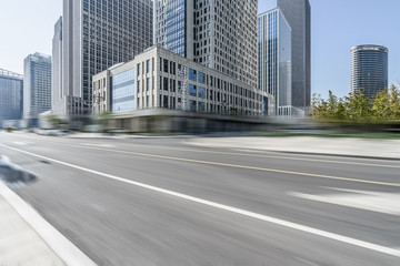 blurred asphalt road front of modern buildings