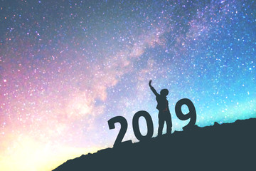 Silhouette young man Happy for 2019 new year background on  the Milky Way galaxy pointing on a bright star. dark sky tone . Vintage grain tone.